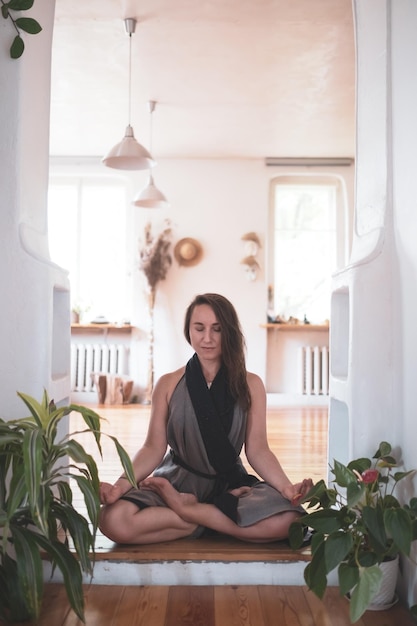 Woman practicing yoga lesson breathing meditating doing\
padmasana exercise