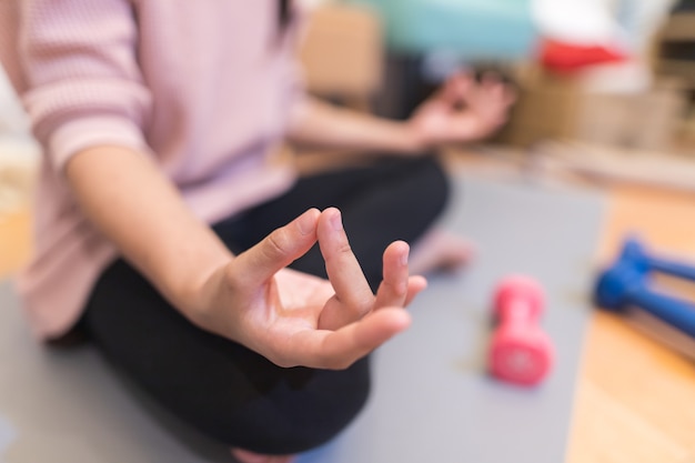 Donna che pratica yoga su un materassino indoor