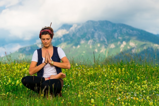 Woman practicing yoga in nature in the mountains