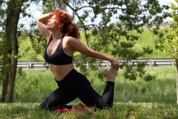 Photo woman practicing yoga at park