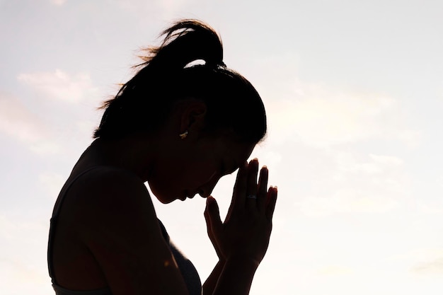 Foto donna che pratica lo yoga in posizione di preghiera