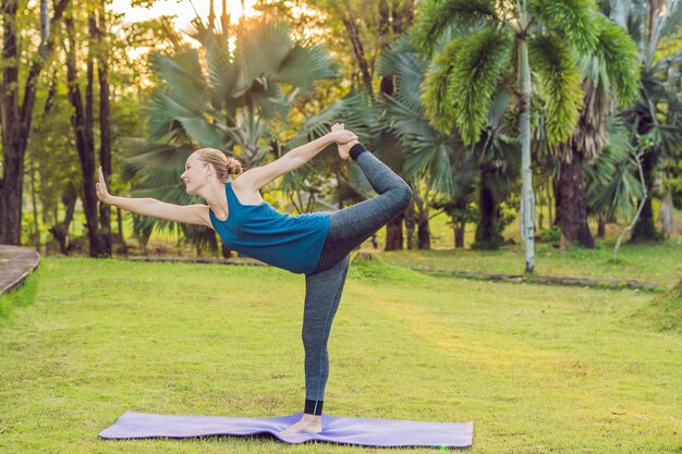 Woman practicing yoga in a tropical park