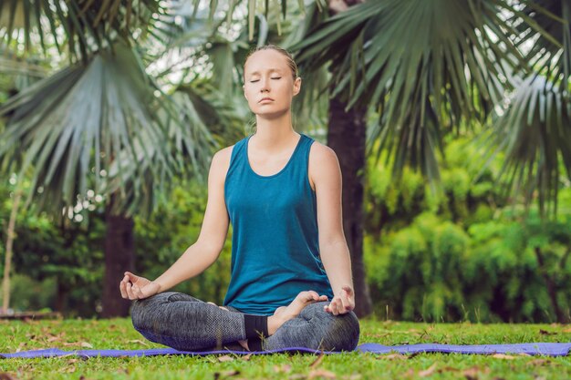 Woman practicing yoga in a tropical park