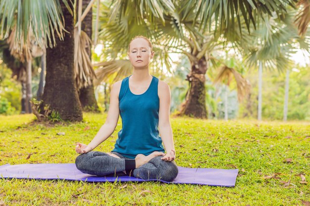 Woman practicing yoga in a tropical park