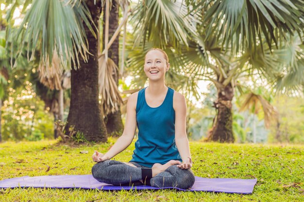 Woman practicing yoga in a tropical park.