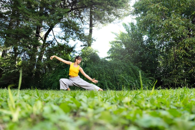 Woman practising tai chi chuan outdoors improving flexibility strength and balance of the body