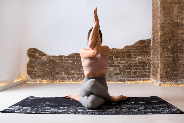 Woman practising yoga asanas indoors