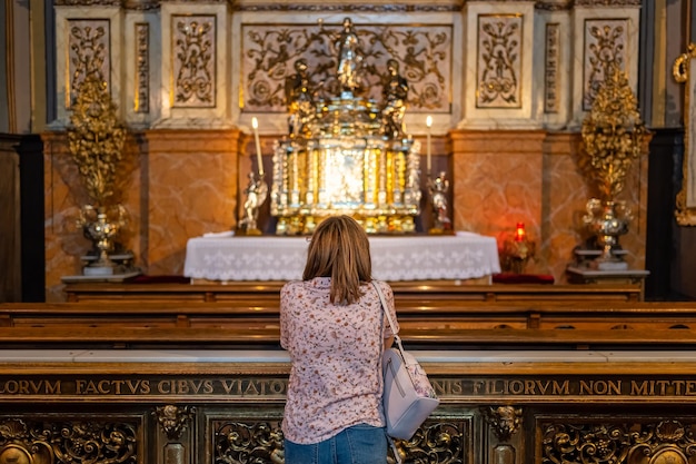 스페인 사라고사(Zaragoza Spain)의 대성당 델 필라르(Basilica del Pilar) 내부 예배당에서 기도하는 여성