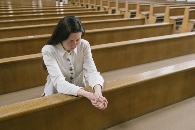 Donna che prega dio in chiesa