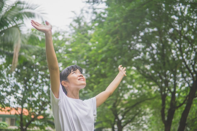 Woman praying to God at the garden in the morning.