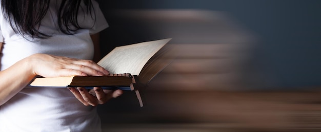 Woman praying holding book and cross