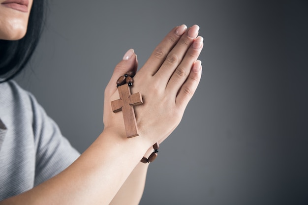 Женщина молится, держа деревянный крест