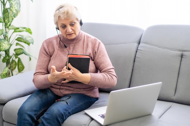 Photo woman praying and worship to god with church online sunday service. live church with bible. woman pray to god. hand praying and palm up on holy bible at home. quarantine from covid-19 coronavirus pand