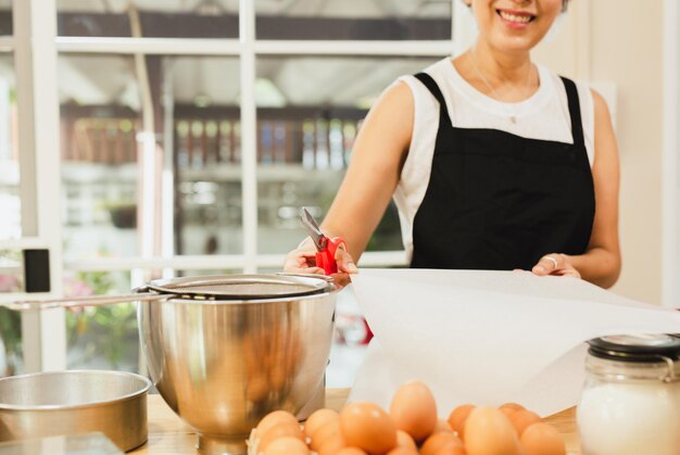 Woman prepare baking cake with hand holding parchment paper