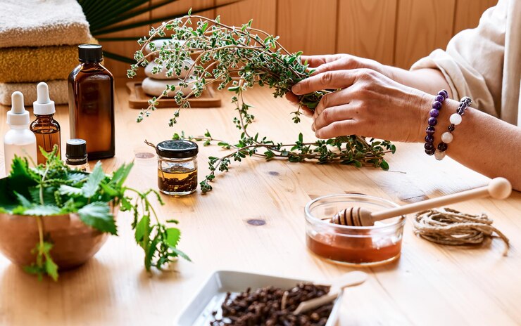 Photo woman prepares aromatherapy session at the table with essential oil and medical herbs