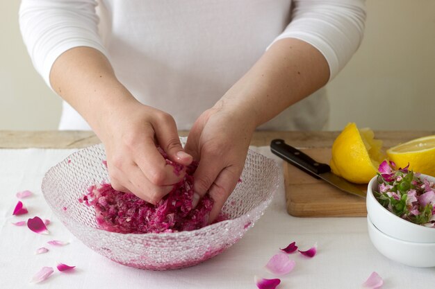 A woman prepares jam from roses