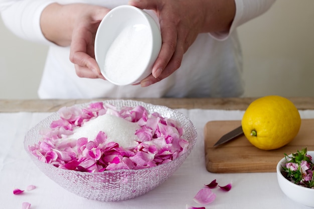 A woman prepares jam from roses