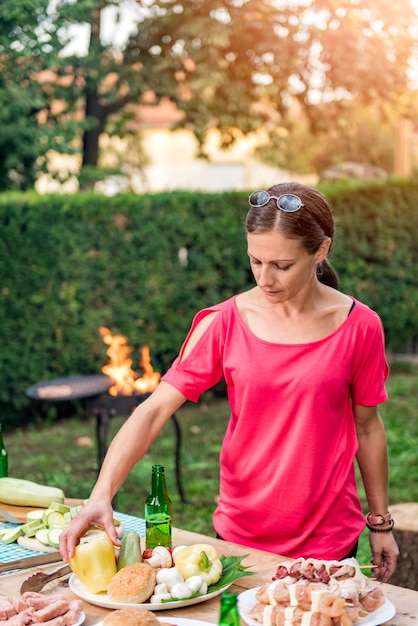 Photo woman preparing barbecue meet on a wooden table