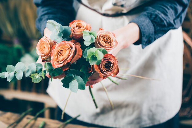 赤いバラの花束を準備する女性