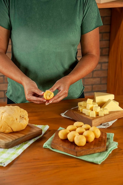Фото Женщина готовит крокеты с начинкой из бразильского сыра bolinha de queijo на деревянном столе