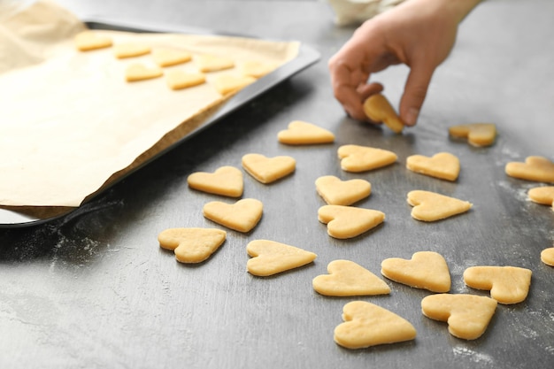 Woman preparing butter cookies on table