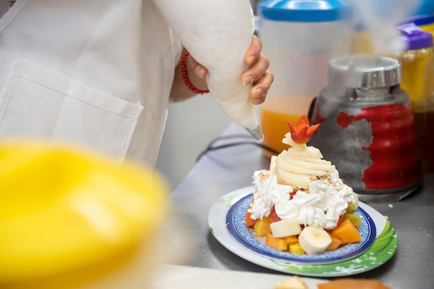 Donna che prepara la frutta del cocktail sul mercato popolare in messico