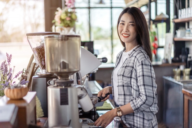 カフェでのマシンでコーヒーを準備する女性