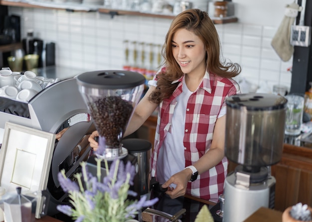 カフェでのマシンでコーヒーを準備する女性