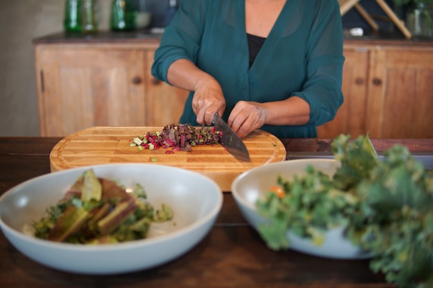 Woman preparing cooking making vegetable salad in kitchen