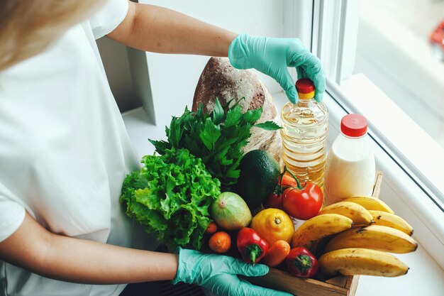 Woman preparing donation box of food for people suffering from coronavirus help during a pandemic fo...