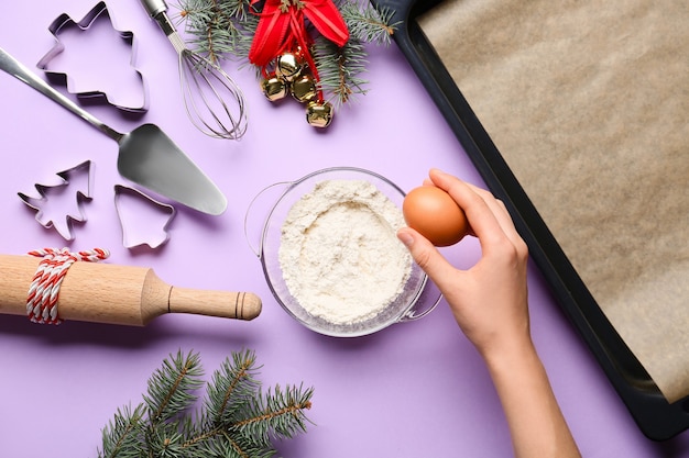 Woman preparing dough on color background