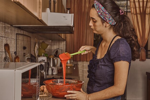 レッド ベルベット ケーキの生地を準備する女性