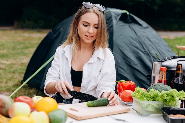 キャンプで屋外の食べ物を準備する女性