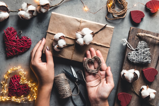 Woman preparing gift for wrapping for Valentine's Day