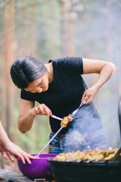 Woman preparing  meat on the grill