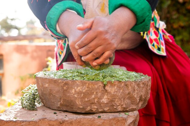 ペルーのチチカカ湖のリャション地方で、植物由来の天然オーガニックシャンプーを準備する女性