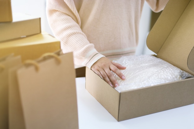 Photo woman preparing package for delivery