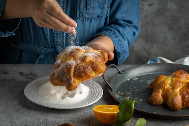 Woman preparing Pan de muertos bread of the dead for Mexican day of the dead