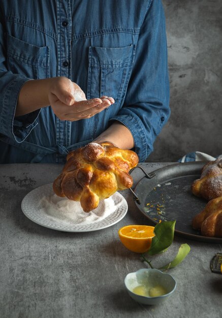 멕시코 망자의 날을 위해 Pan de muertos 빵을 준비하는 여성