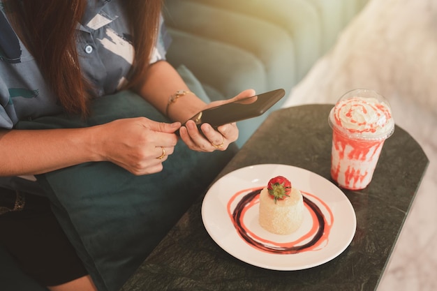 Woman preparing to photograph cakes and drinks Piccolo Latte brownies and breakfast on wooden tabl