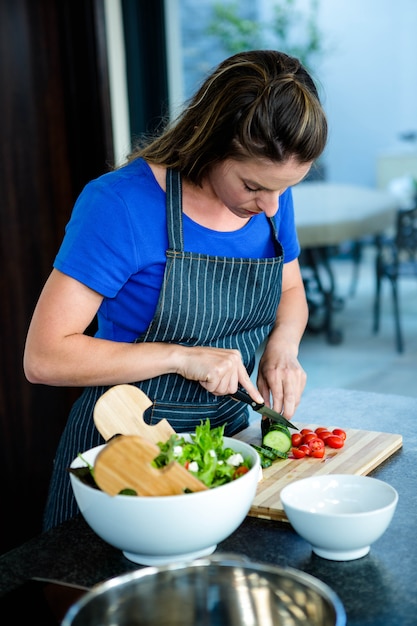 woman preparing sliced vegetable for dinner in the kitchen