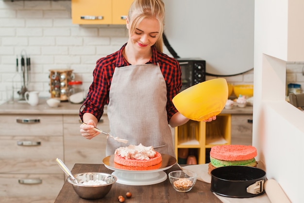 Foto donna che prepara una torta dolce fatta in casa sulla tavola di legno della cucina