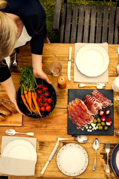 庭の夕食のテーブルを準備している女性