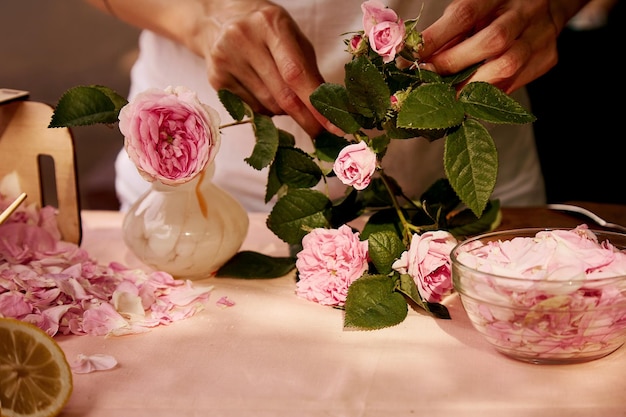 Woman preparing tea roses petals Aesthetic homemade natural tea rose jam preparing with sugar lemon and tea rose petals Healthy recipe Lifestyle photography Selective focus