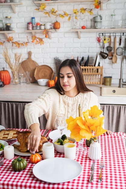 Woman preparing thanksgiving dinner at home kitchen decorating