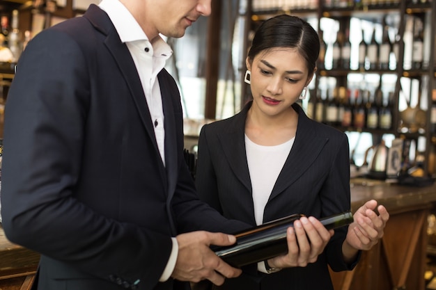 Woman present wine for Businessman at Bar