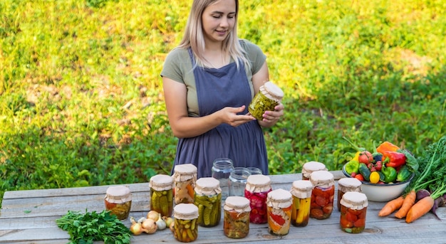 A woman preserves vegetables in jars Selective focus Food