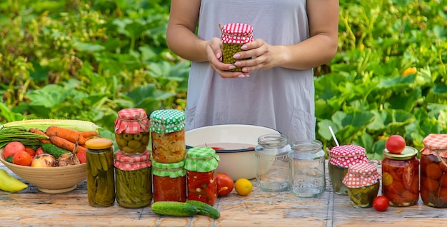 A woman preserves vegetables in jars Selective focus