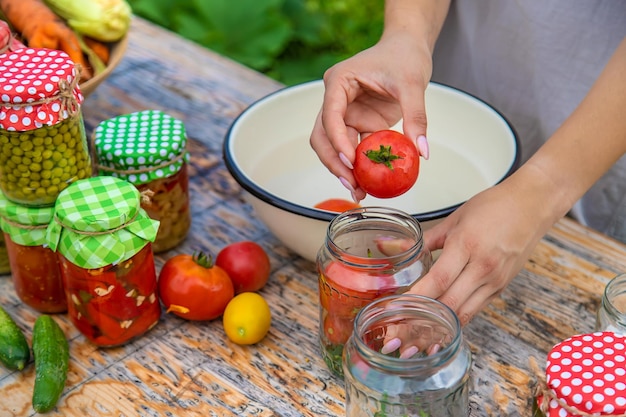 A woman preserves vegetables in jars Selective focus