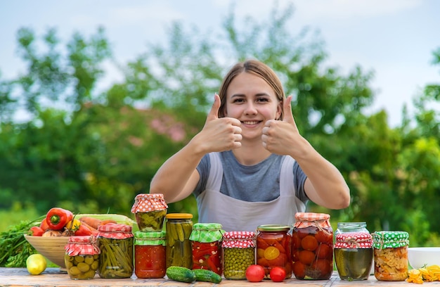 Женщина консервирует овощи в банках Избирательный фокус